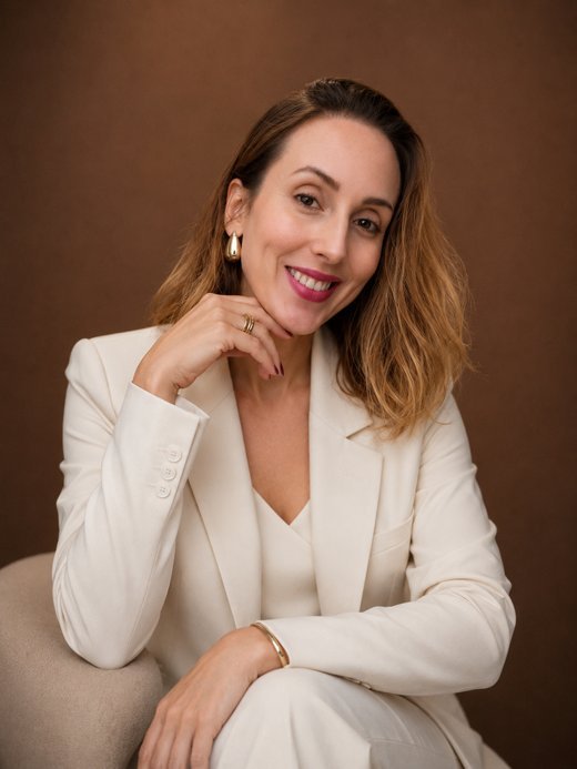 Danielle Flores, nutricionista, sorrindo, de terno claro